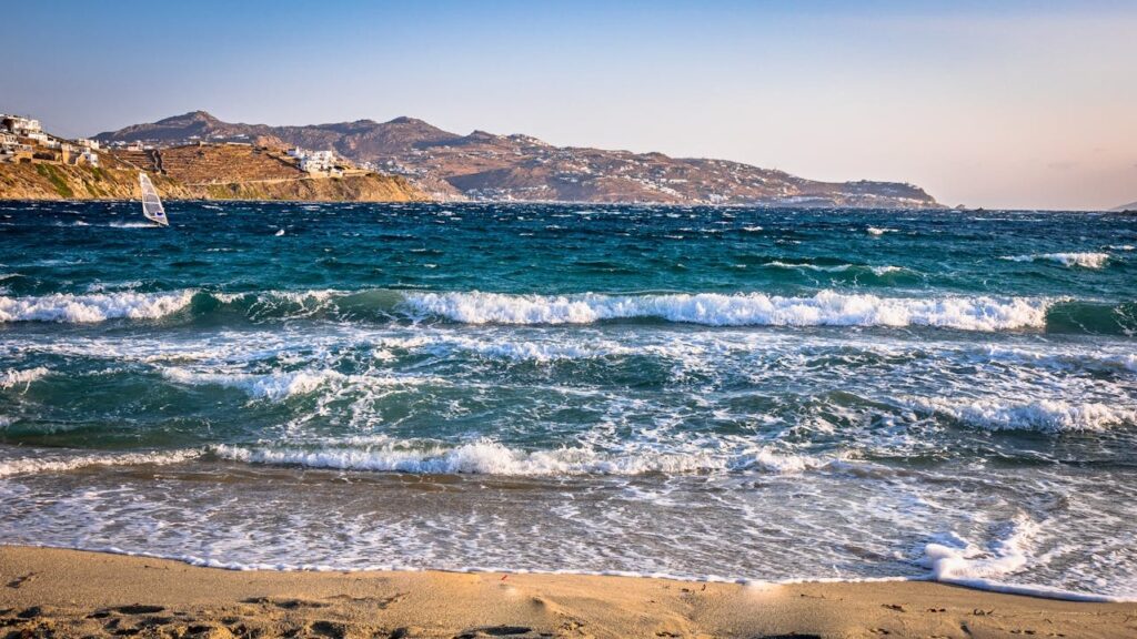 The beach, ocean, and mountains, with a wind surfer