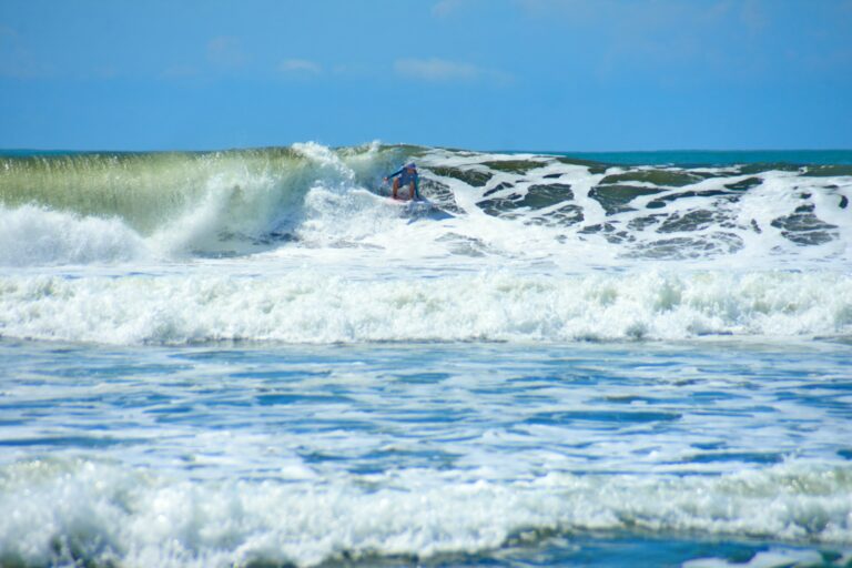 Surfer surfing a wave in Dominical, Costa Rica
