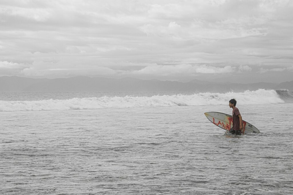 Surfer walking out to the lineup in Costa Rica Pavones