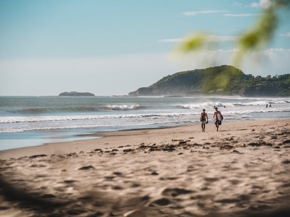 Two surfboarders walking on the beach in Nicaragua