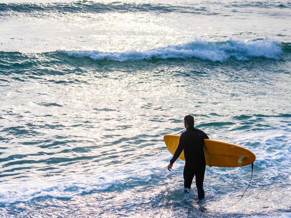 Photo of a surfer walking into the water