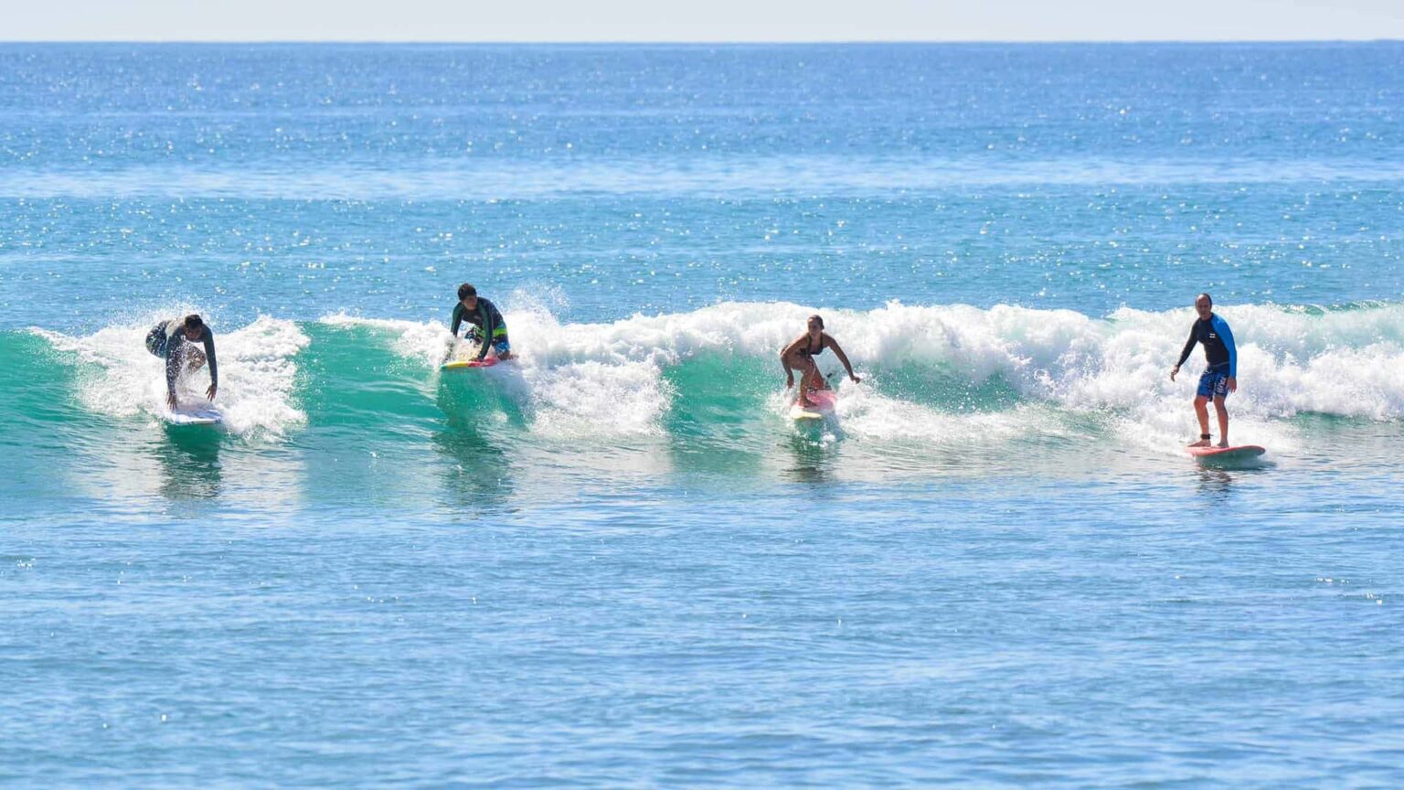 A group of beginner surfers enjoying a lesson with High Tide Los Cabos.