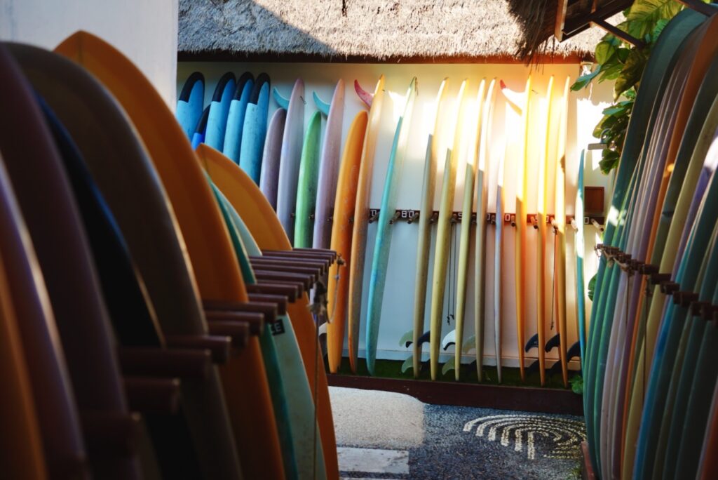 A photo of a ton of surfboards avaliable in the LMBK Surf House.
