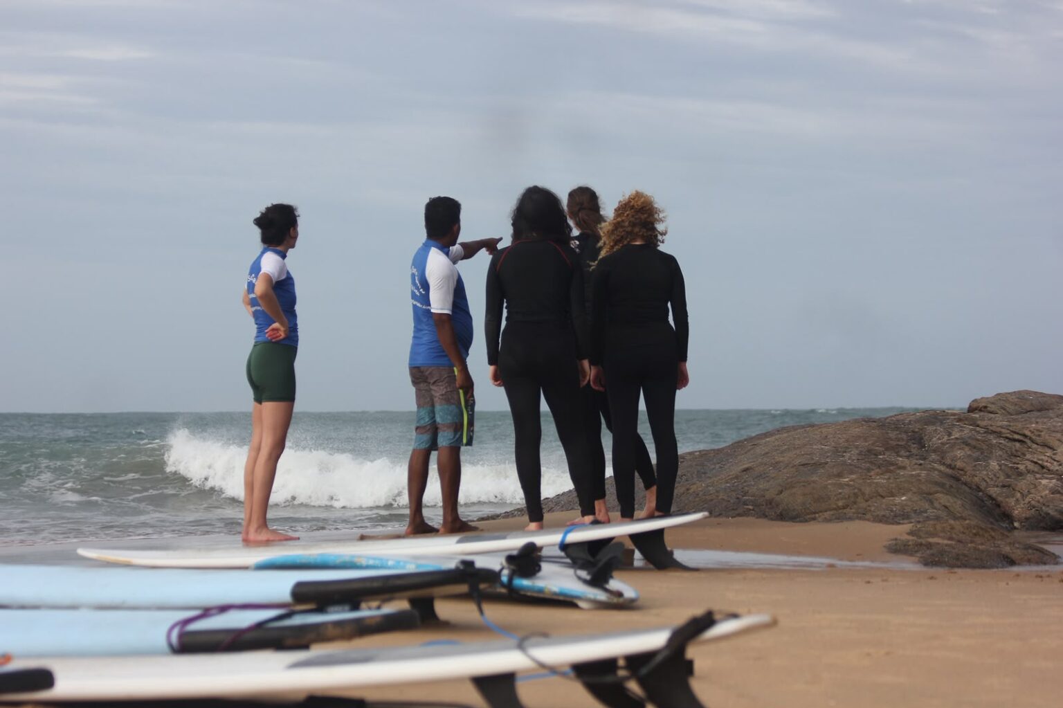 Fawas, owner of SAFA Surf & Yoga showing some of the students how to properly approach surfing at Arugam Bay.