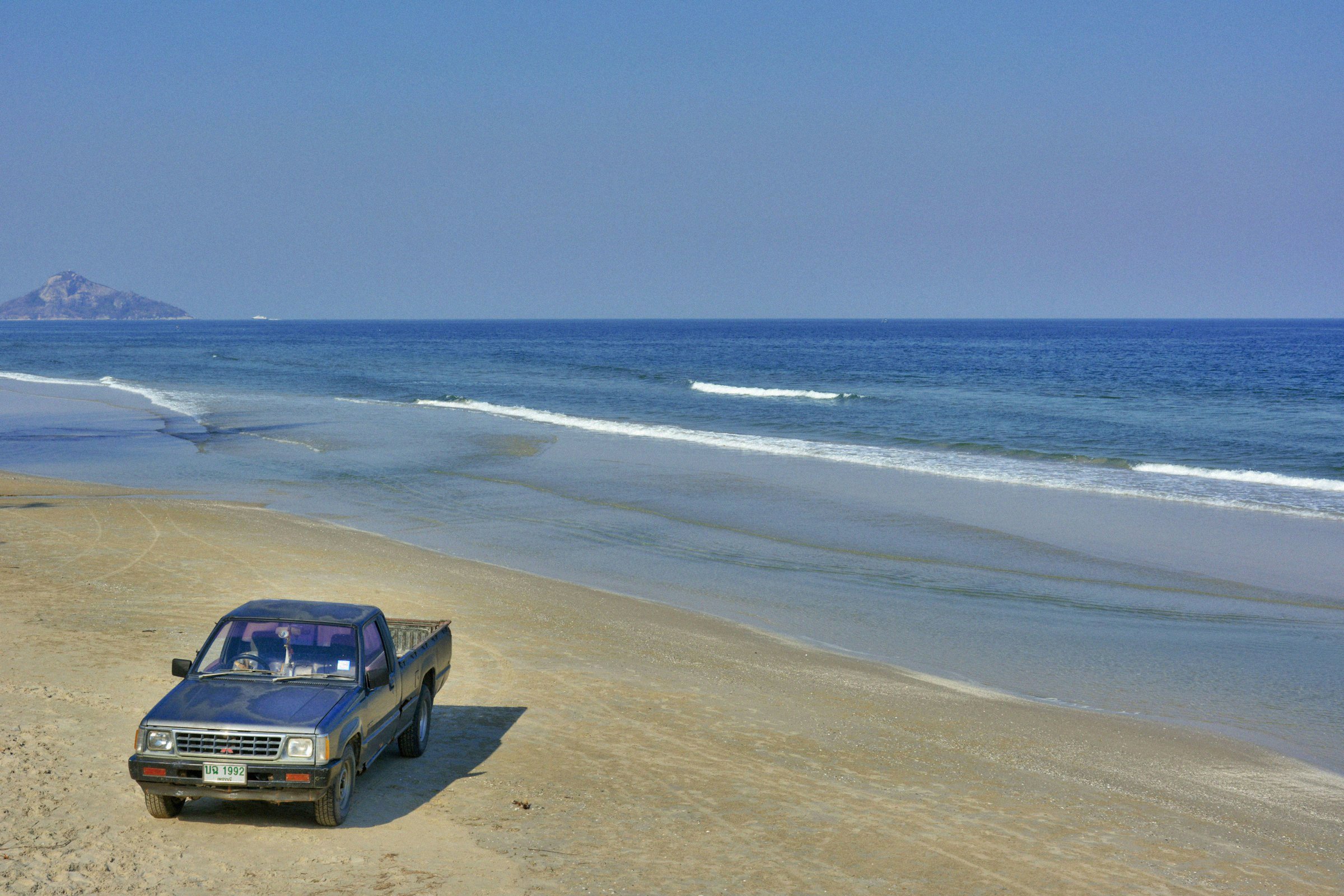 A beach with a truck on it.