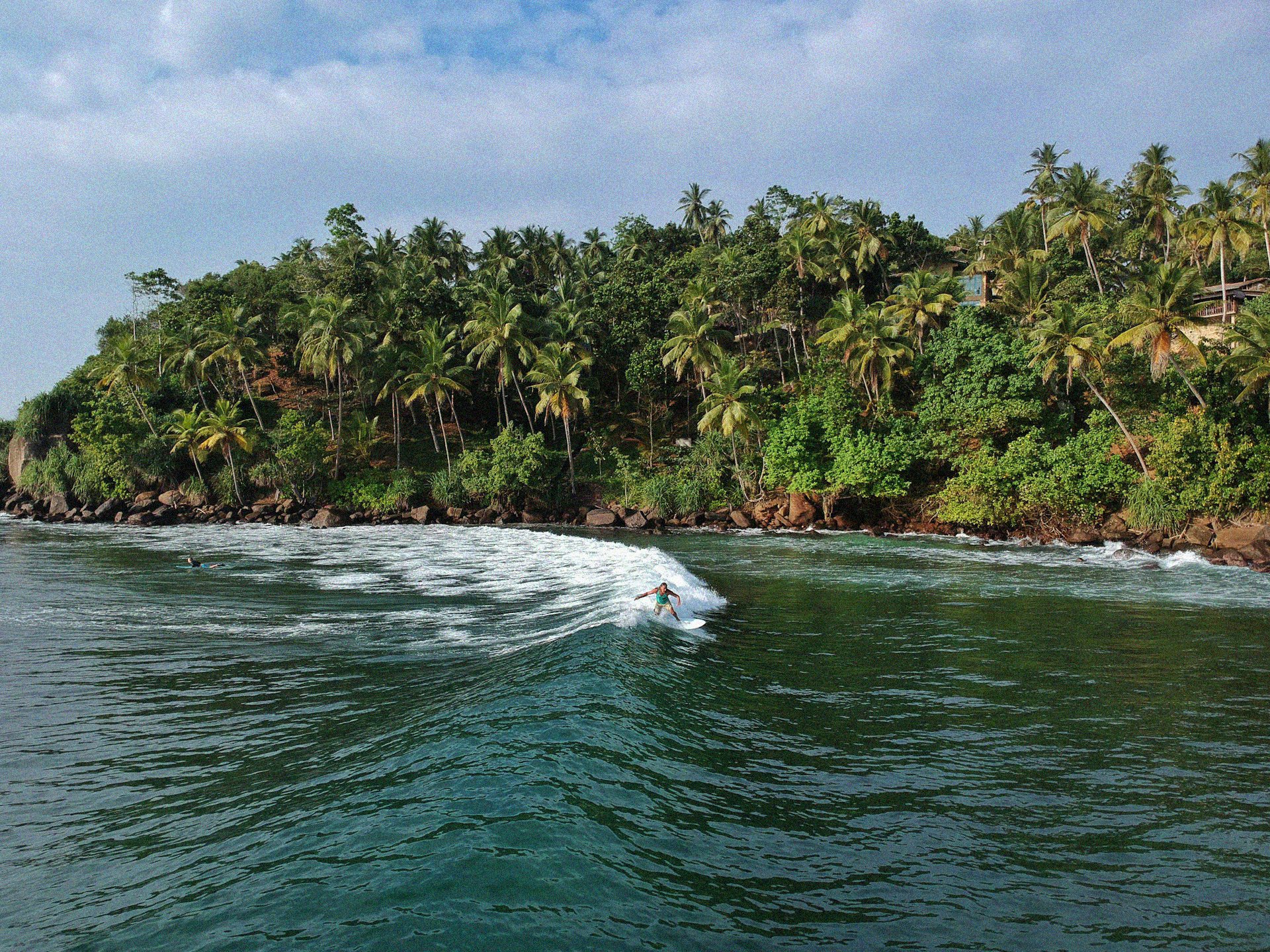 A surfer riding a fun wave in Mirissa.