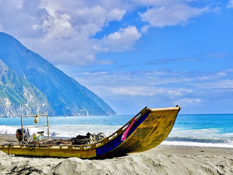 A boat laying on the shore of a Taiwan beach