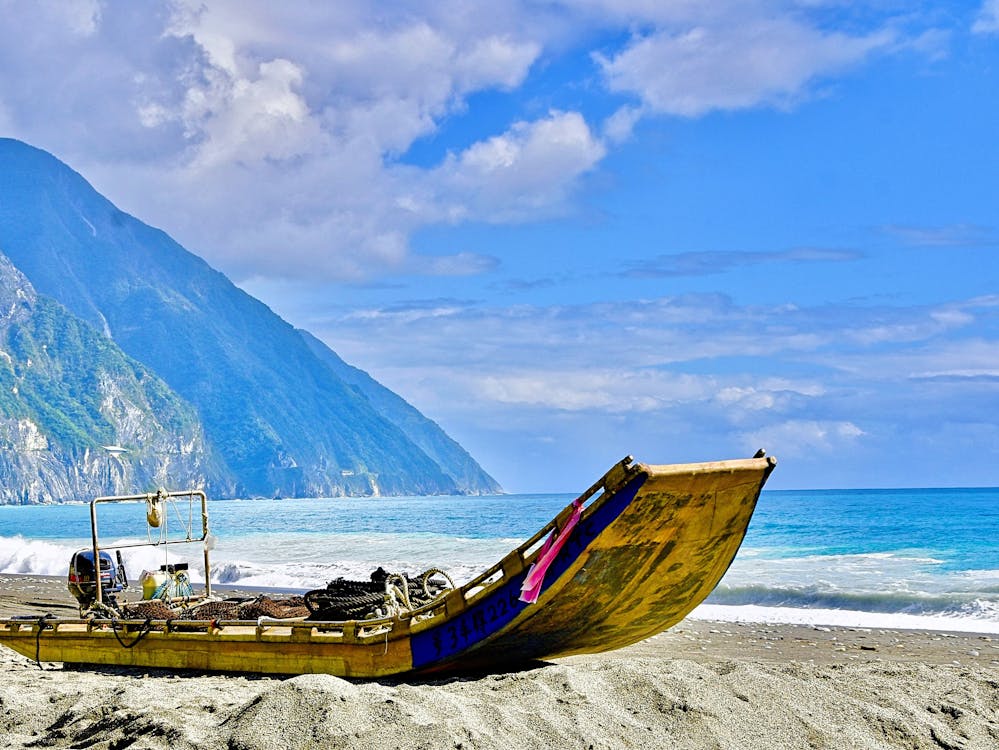 A boat laying on the shore of a Taiwan beach