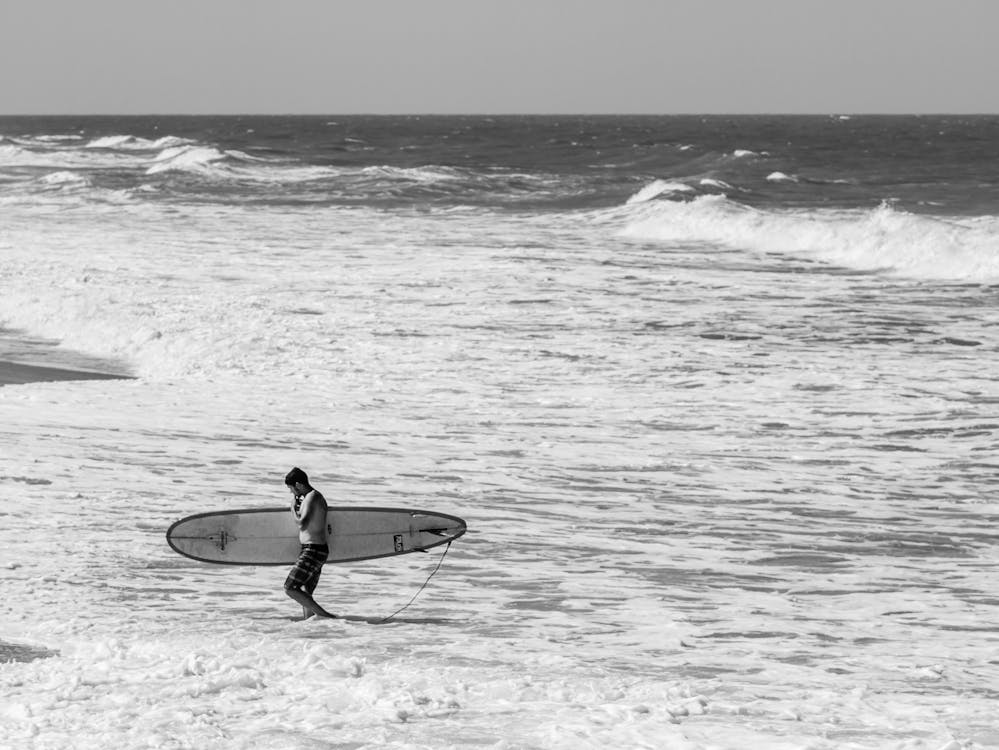 Surfing in Jacaraipe, Brazil...a surfer walking out with his longboard