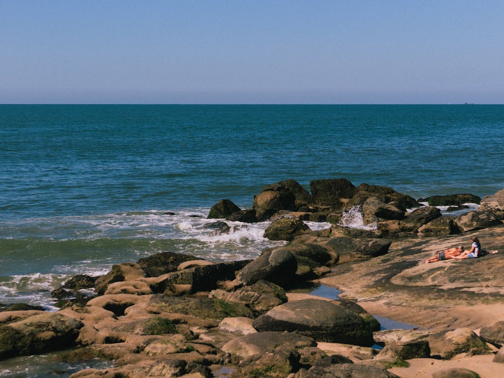 Some people laying next to the peak of Matinhos