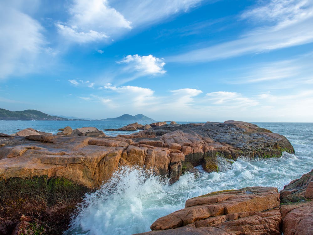 A coastal rock display with waves breaking over it