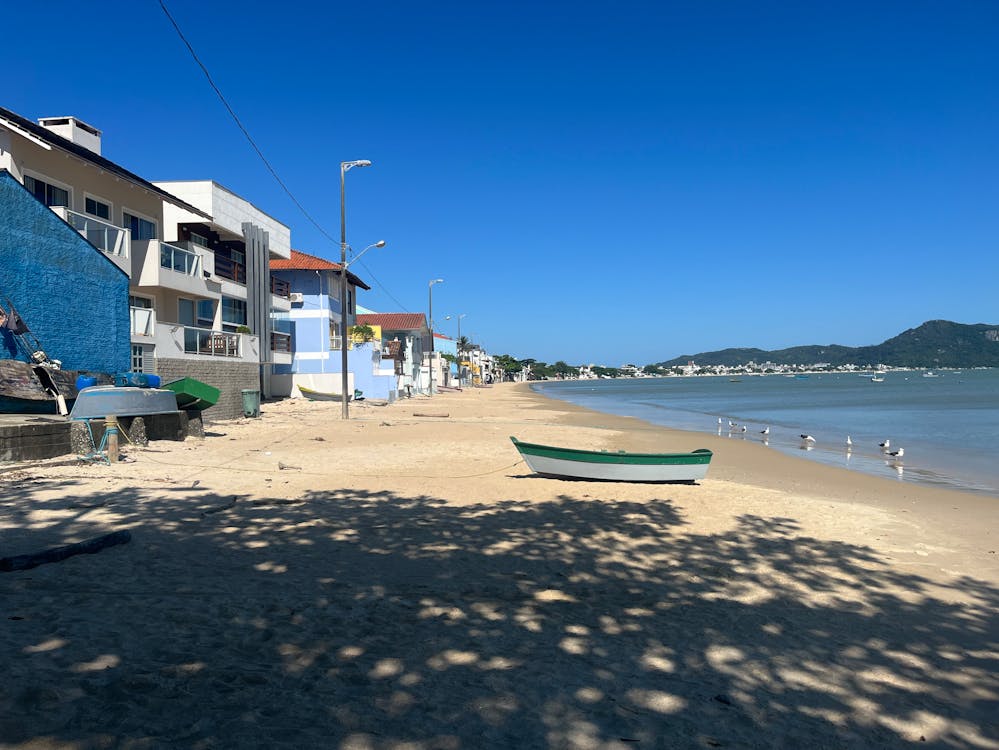A small boat laying on the beach with no waves in sight
