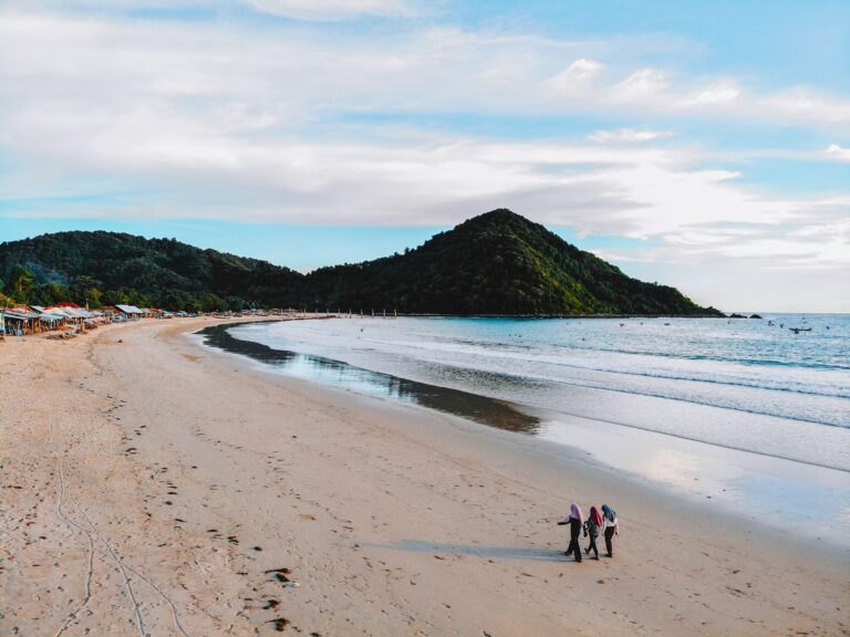 Some people walking along the beach of Selong Belanak