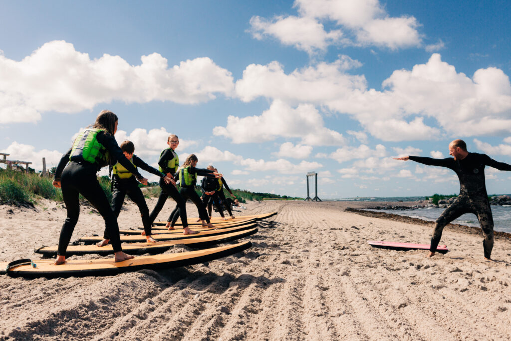 A handful of beginners getting their first surf lessons from Surflogiet.
