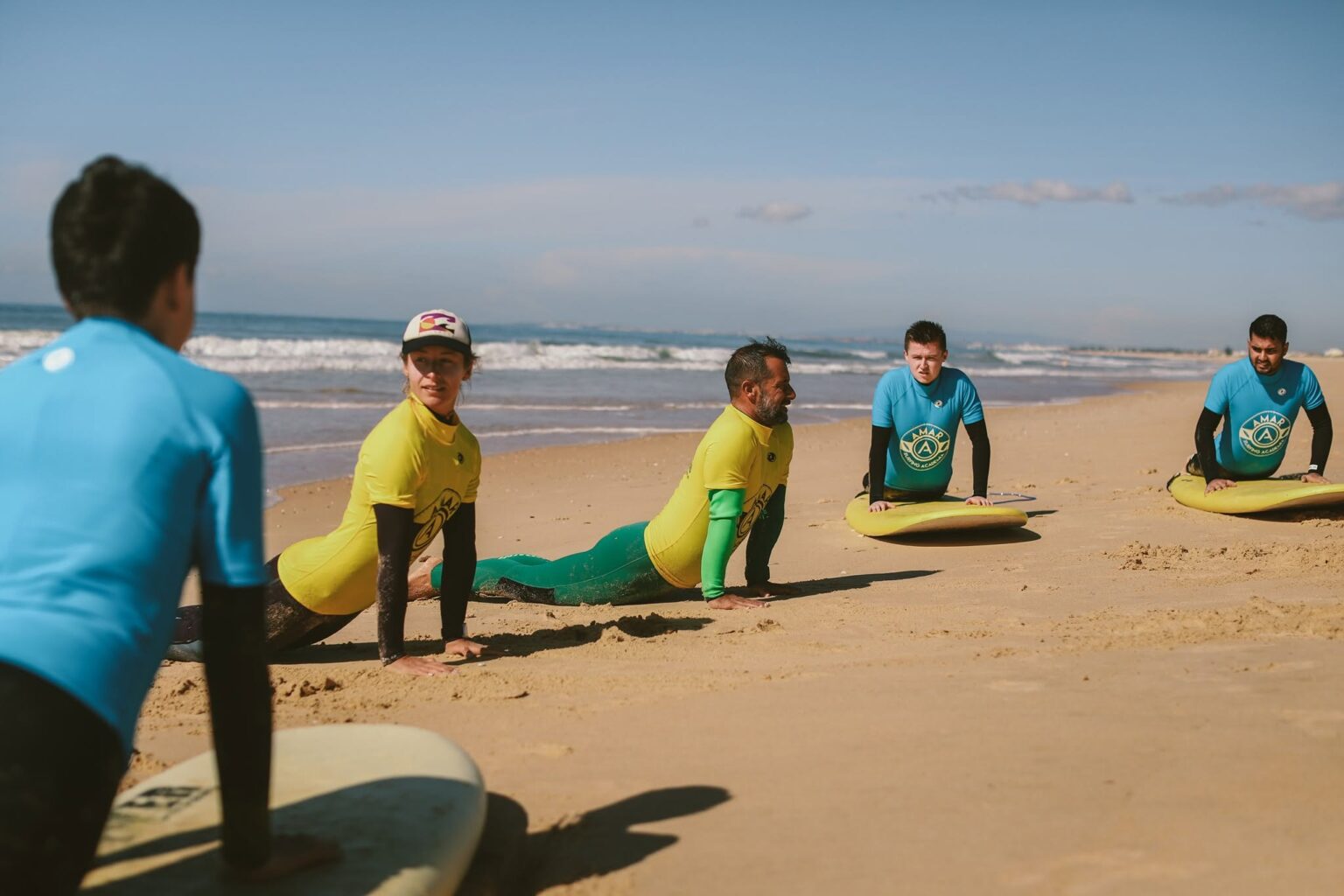 The team at AMAR Surfing Academia showcasing the proper popup technique to some students.