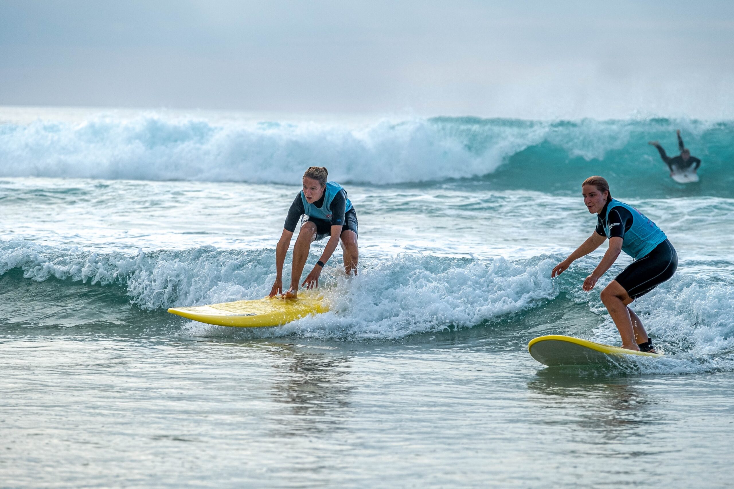 Two beginners learning the pop-up and ride methodology with Ocean Lovers Surf School.