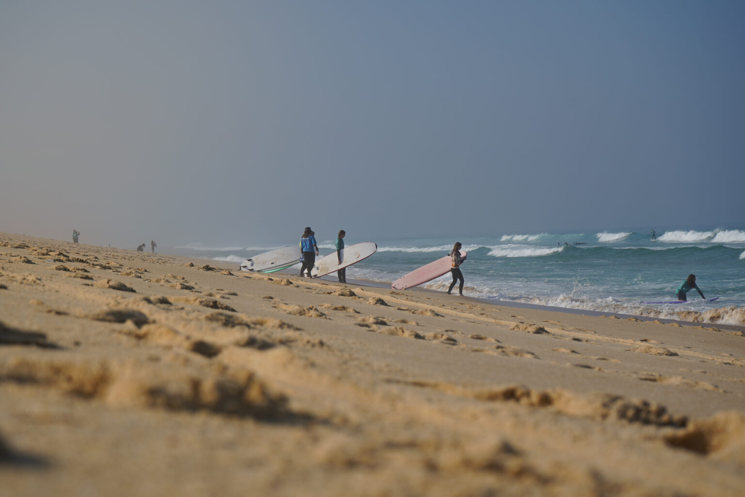 A group of Imagine Surf School students heading into the water.