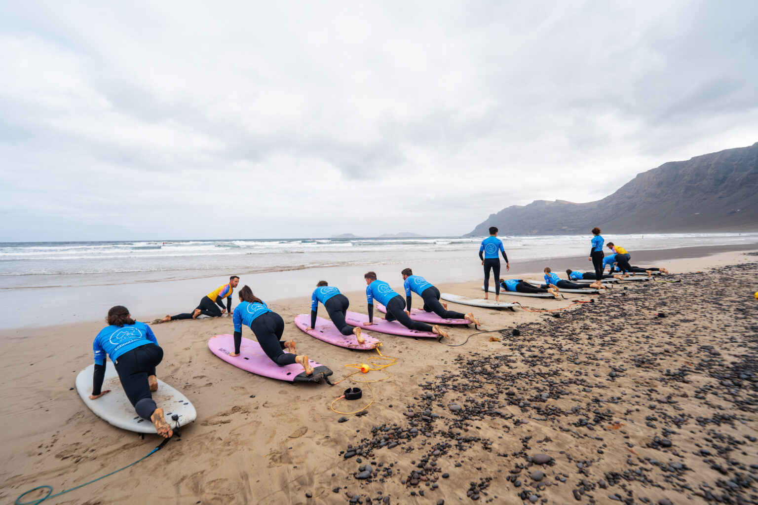 A lineup of surf learners getting there on-shore practice with surf schooln School3S.