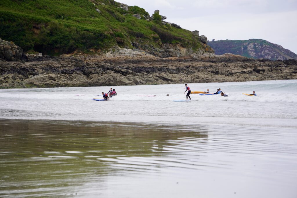 A group of surfers enjoying a lesson with Surfing Locquirec.