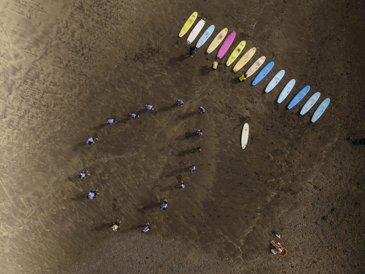 A beautiful drone shot of School3S lining up on the beach and getting ready to hit the water.