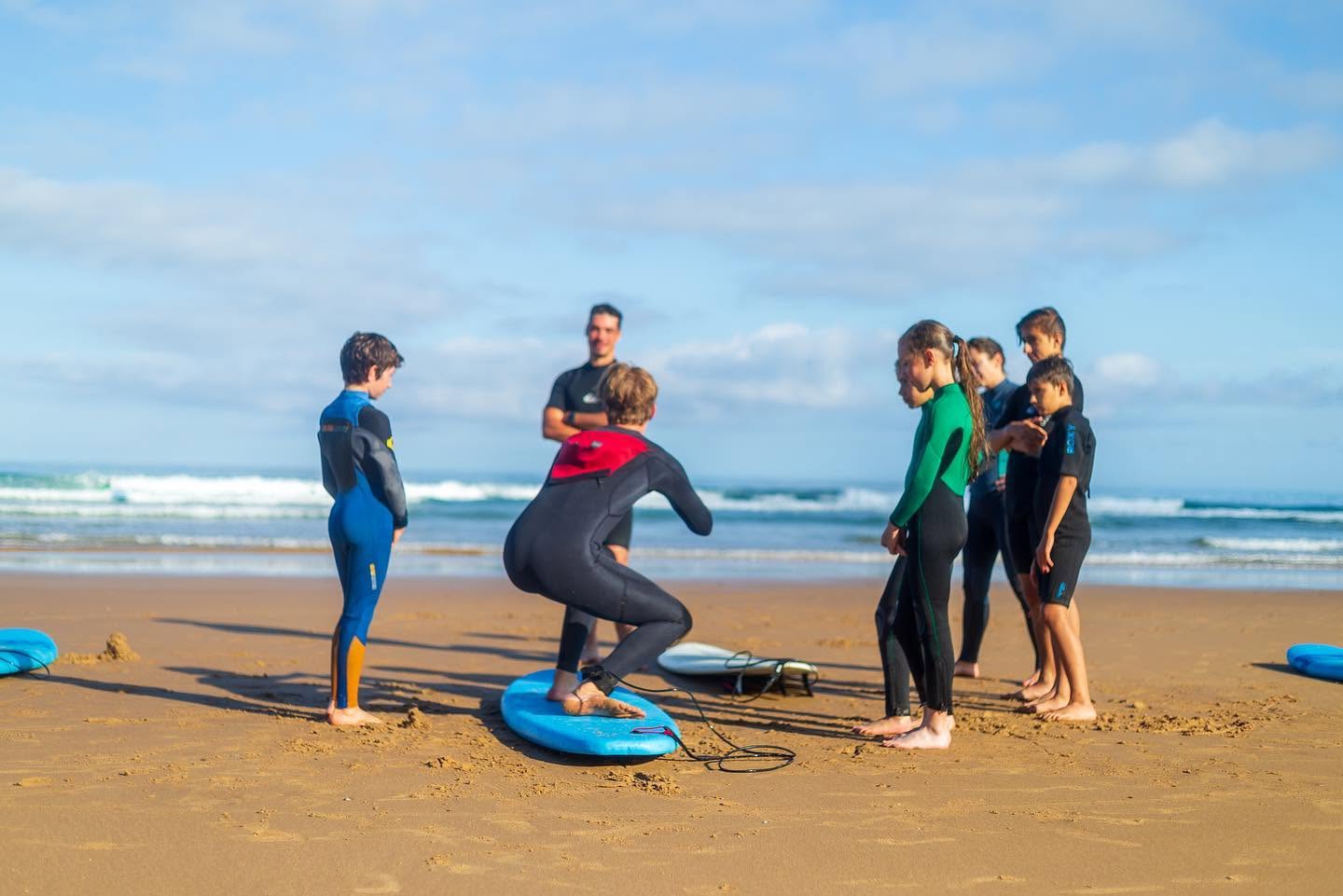 Julien, founder and instructor of Habia Surf School, teaching some groms the proper stance on a surfboard.