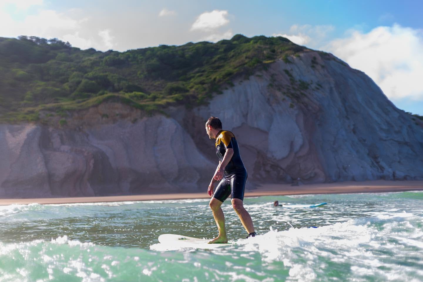 A student from Habia Surf School enjoying a wave along the coastline.