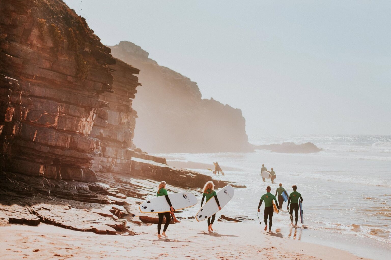 Odeceixe Surf School walking along the coast and preparing themselves for a fun surf session.