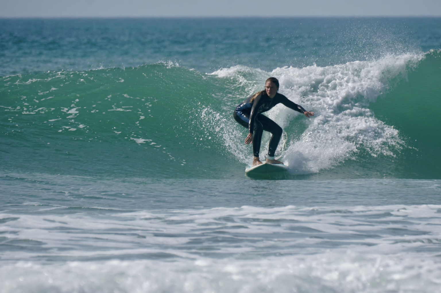 A student at Mad Wax Surf School catching a beautiful wave.
