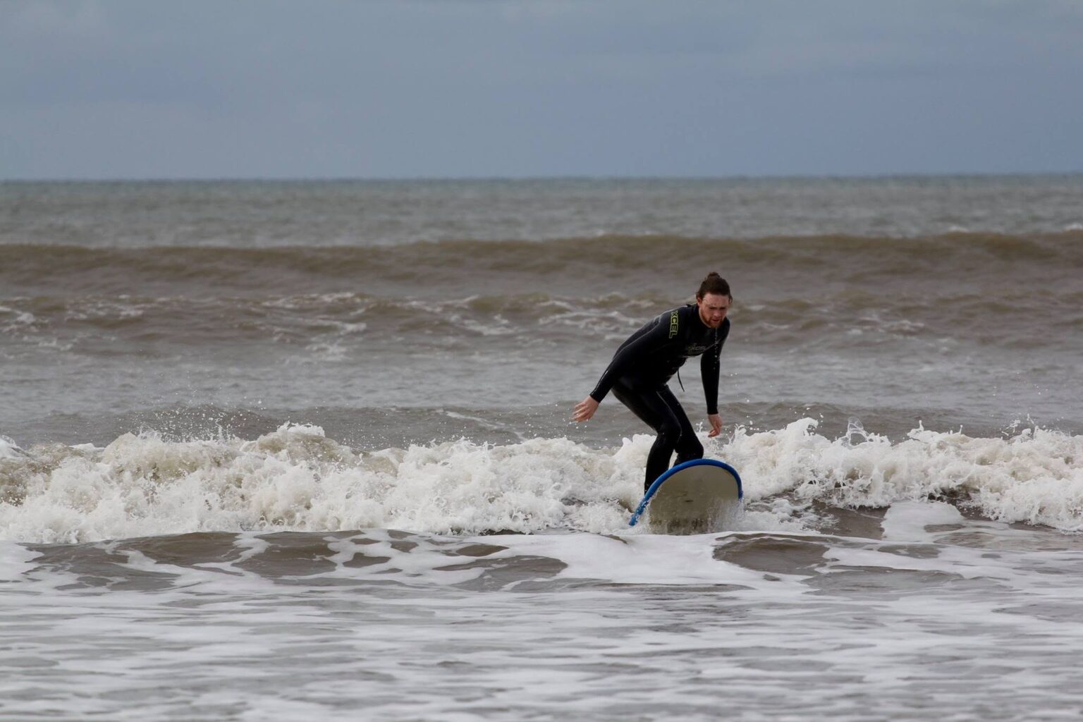 A surf lesson participate catching a wave with AberAdventures.
