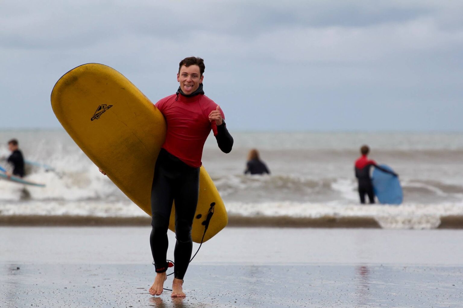 One of the surfers from AberAdventures throwing some thumbs up after a solid surf session in the water.