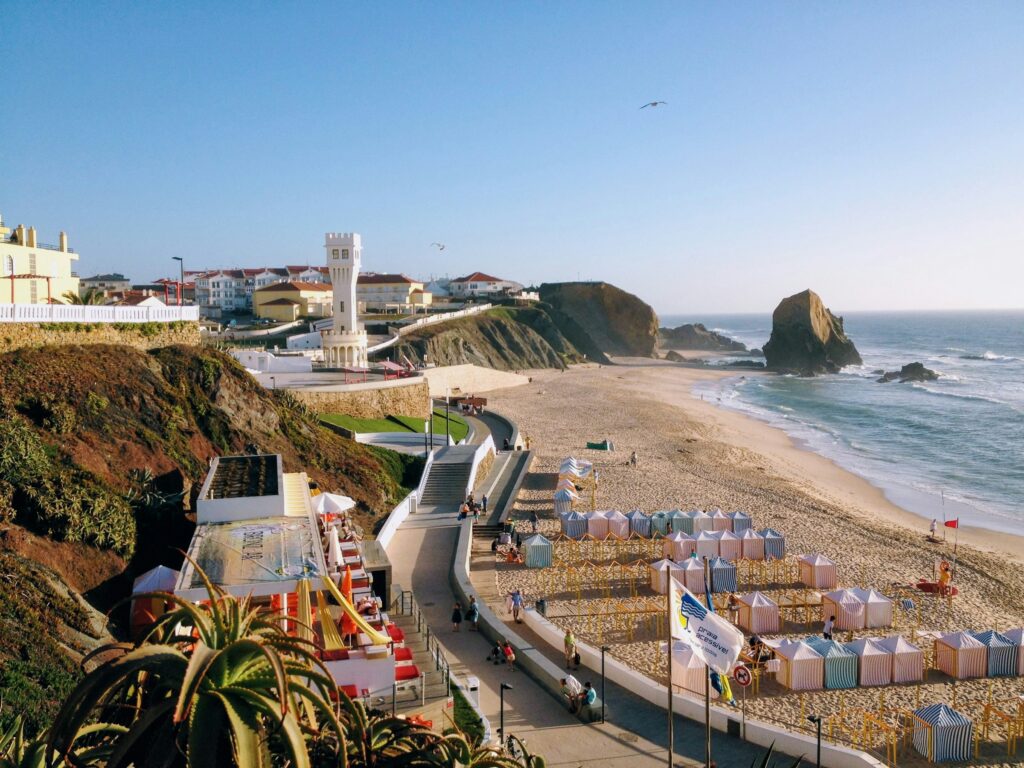 A beautiful shot of Santa Cruz beach in Portugal. Beach umbrellas, waves, and water!