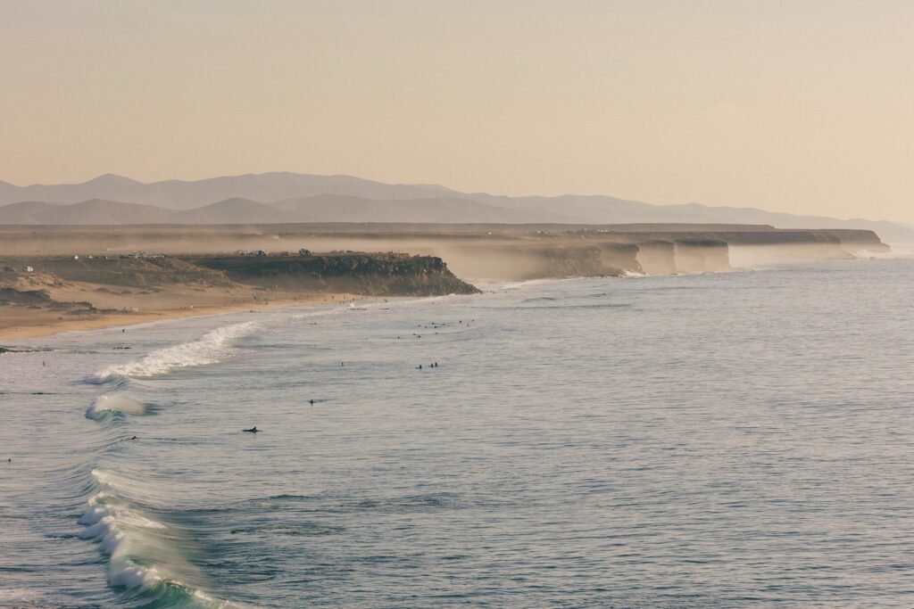 A gorgeous shot of El Cotillo Beach with surfers filling the water.