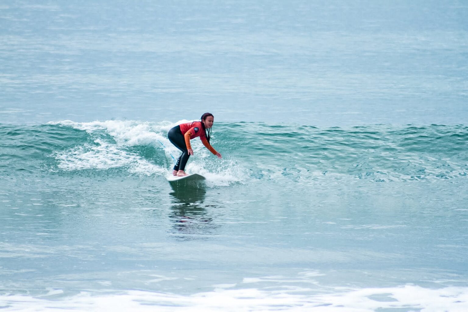 A student of Future Eco Surf enjoying a ride on a wave alongside the beautiful coastline of Portimão.