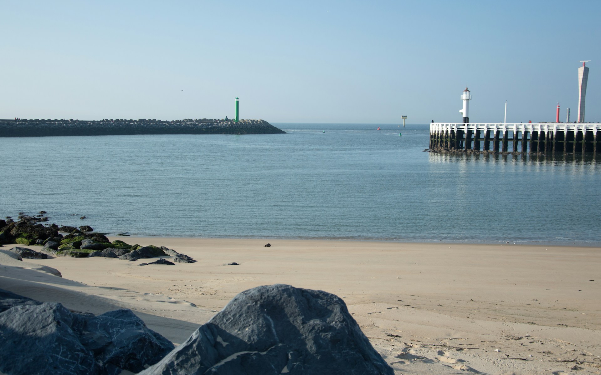The harbor of Oostende in all its beauty with golden sand and flat as ever ocean water.