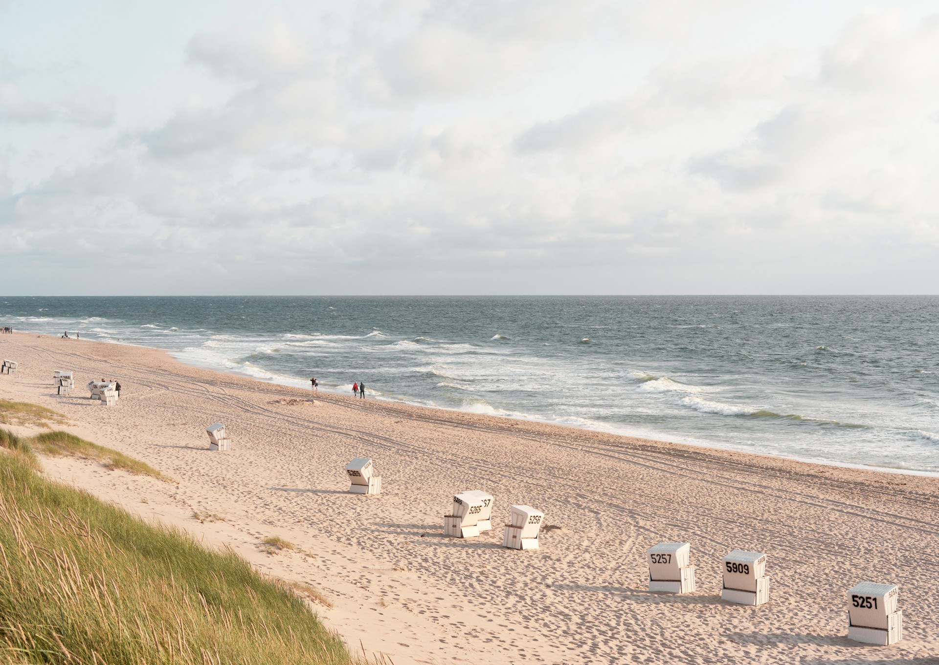A landscape shot of Sylt with some windchopped waves and glamorous beach.