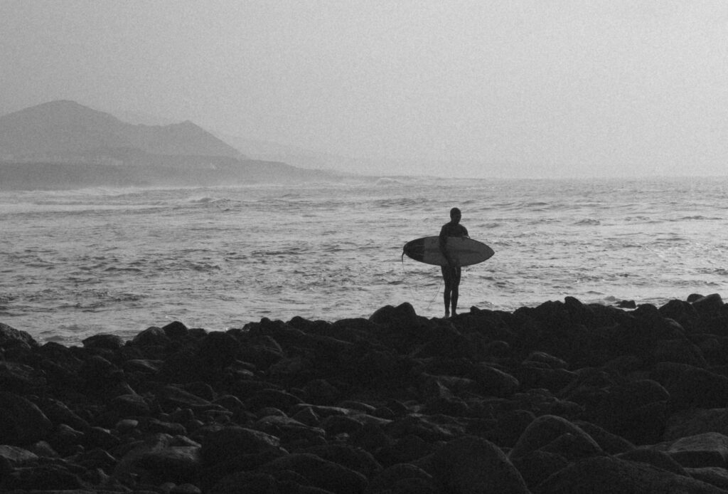 A surfer posing on the cliffs during a dawn patrol session.