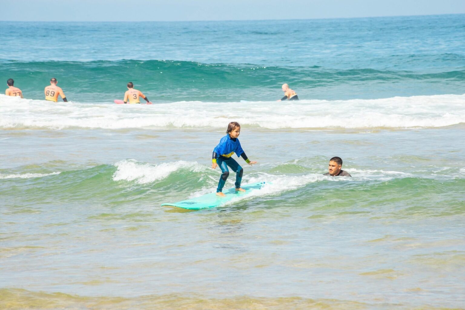 A grom enjoying a wave with Moana Surf School.