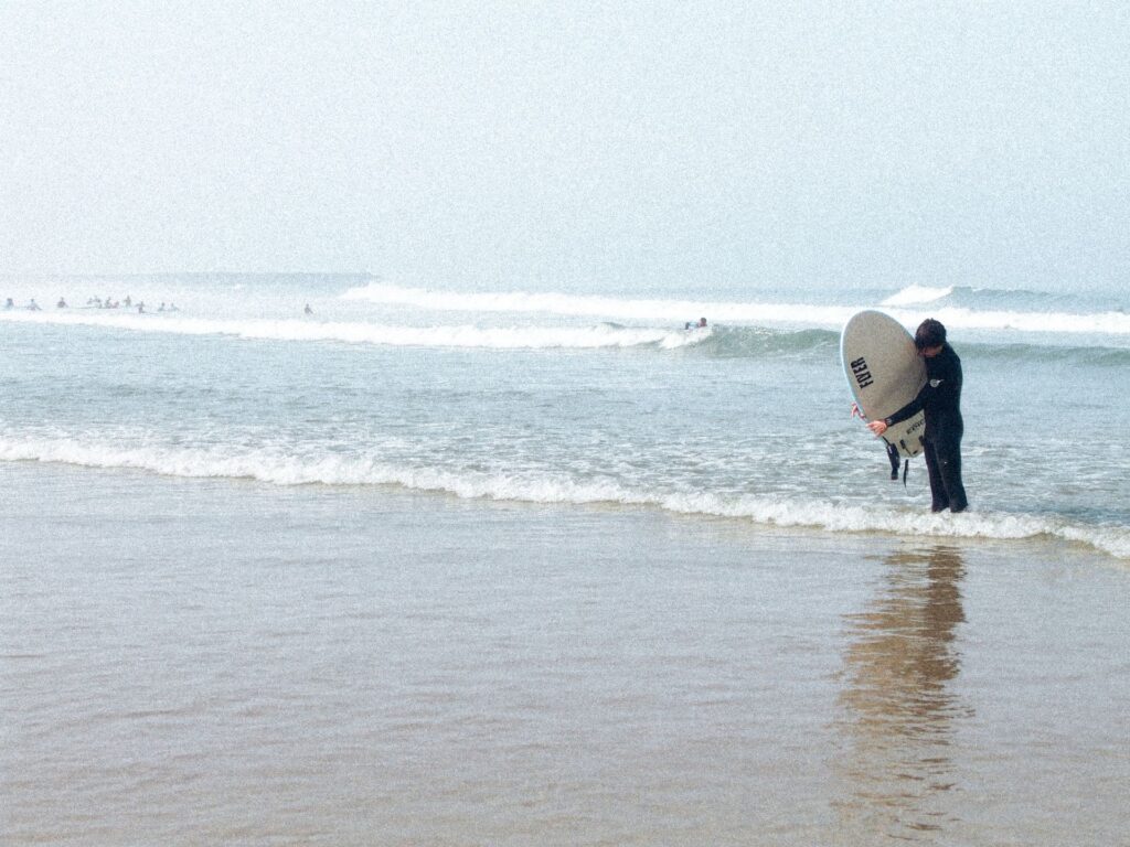 A surfer pictured wrapping their leash around their board along one of the many beaches in Espinho, Portugal
