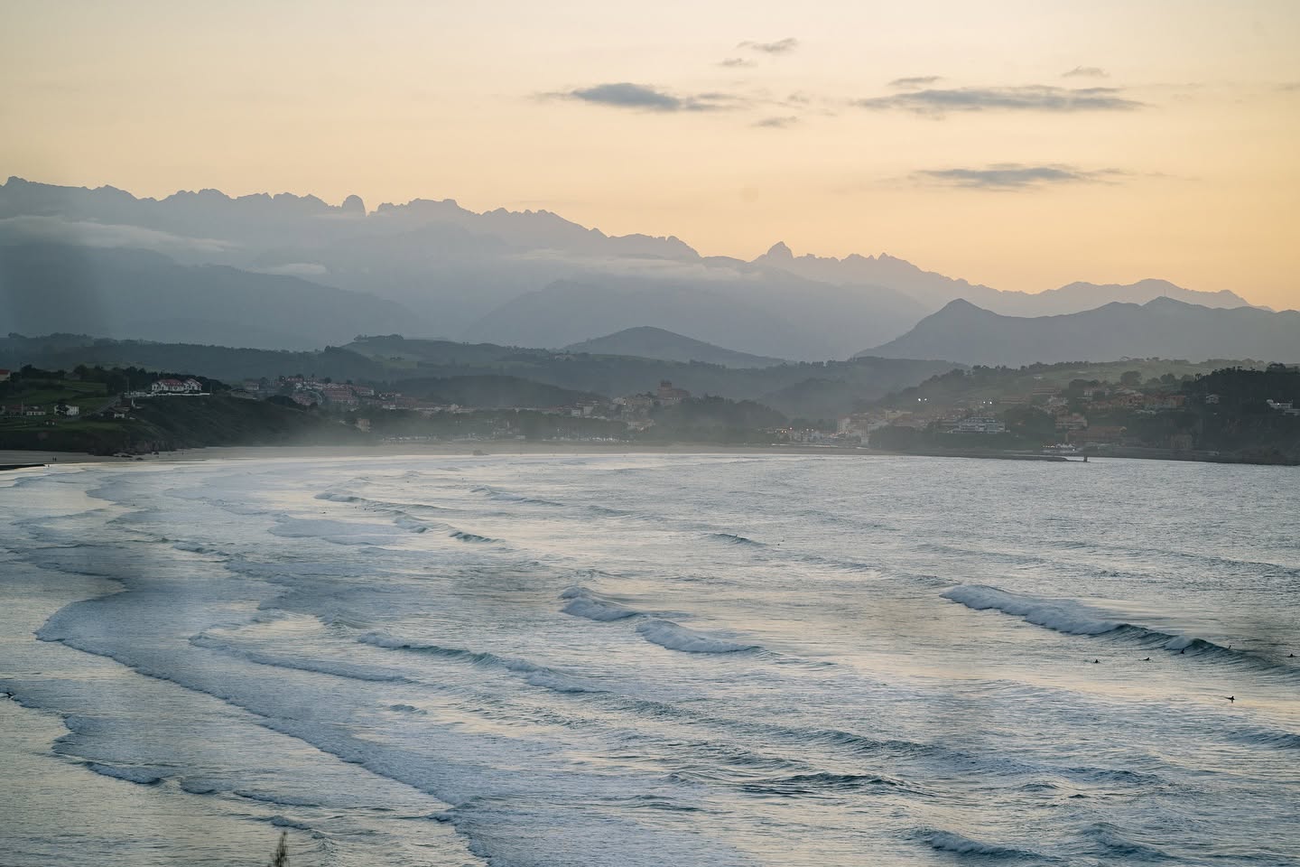 A sunset view of San Vicente featuring some waves and surfers enjoying them.
