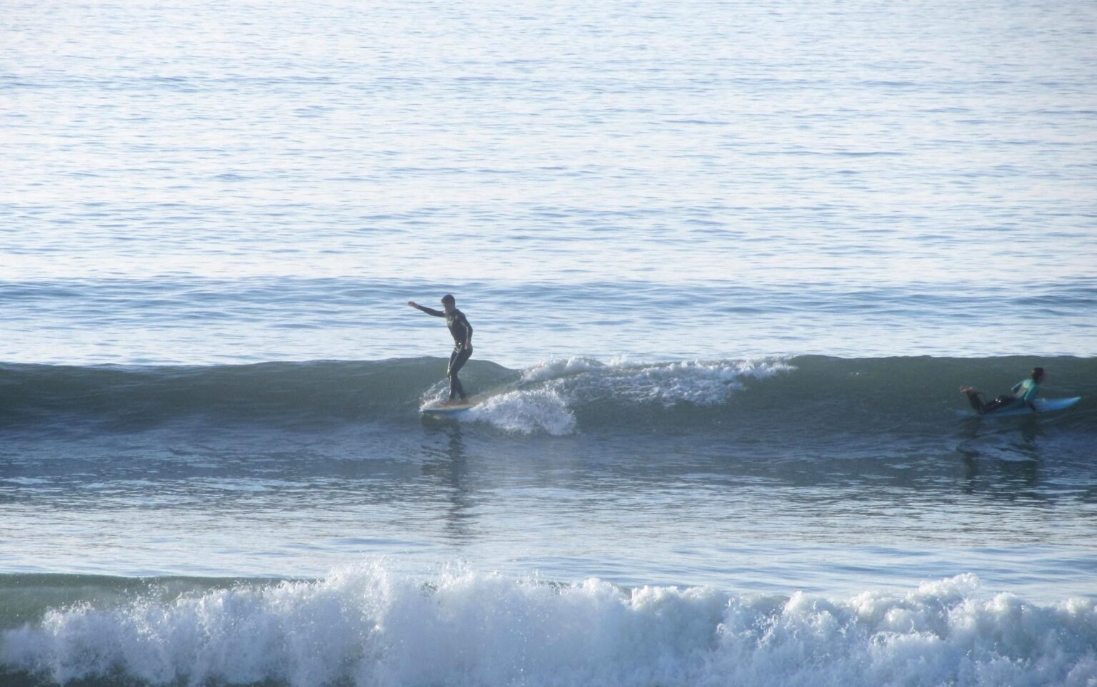 An instructor from North Devon Surf School showing how to ride in the waves in Westward Ho!