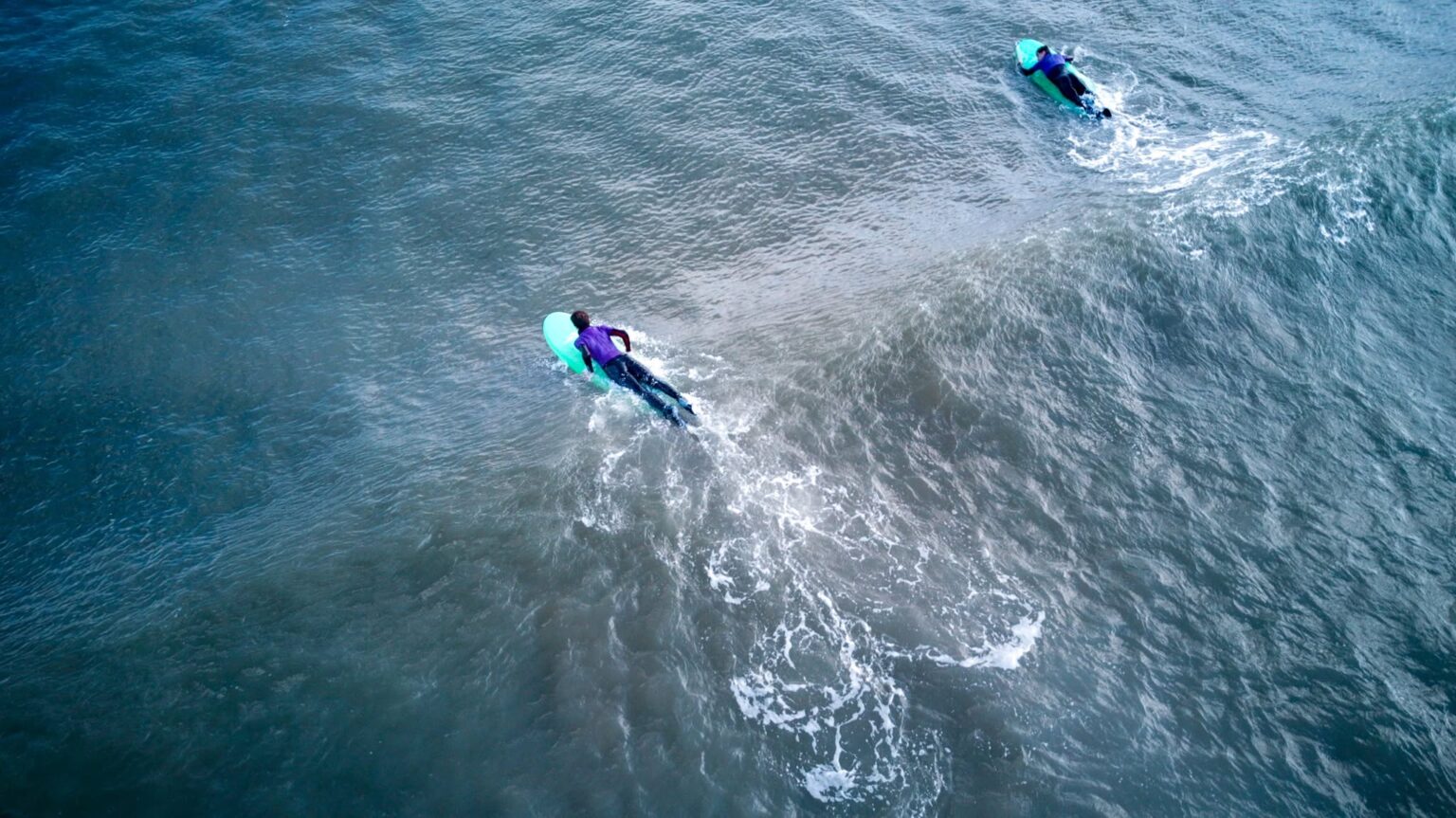The North Devon Surf School having some fun in the water on a sunny day.